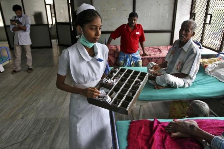 A paramedic distributes free medicine provided by the government to patients inside a ward at Rajiv Gandhi Government General Hospital (RGGGH) in Chennai July 12, 2012. REUTERS/Babu/Files