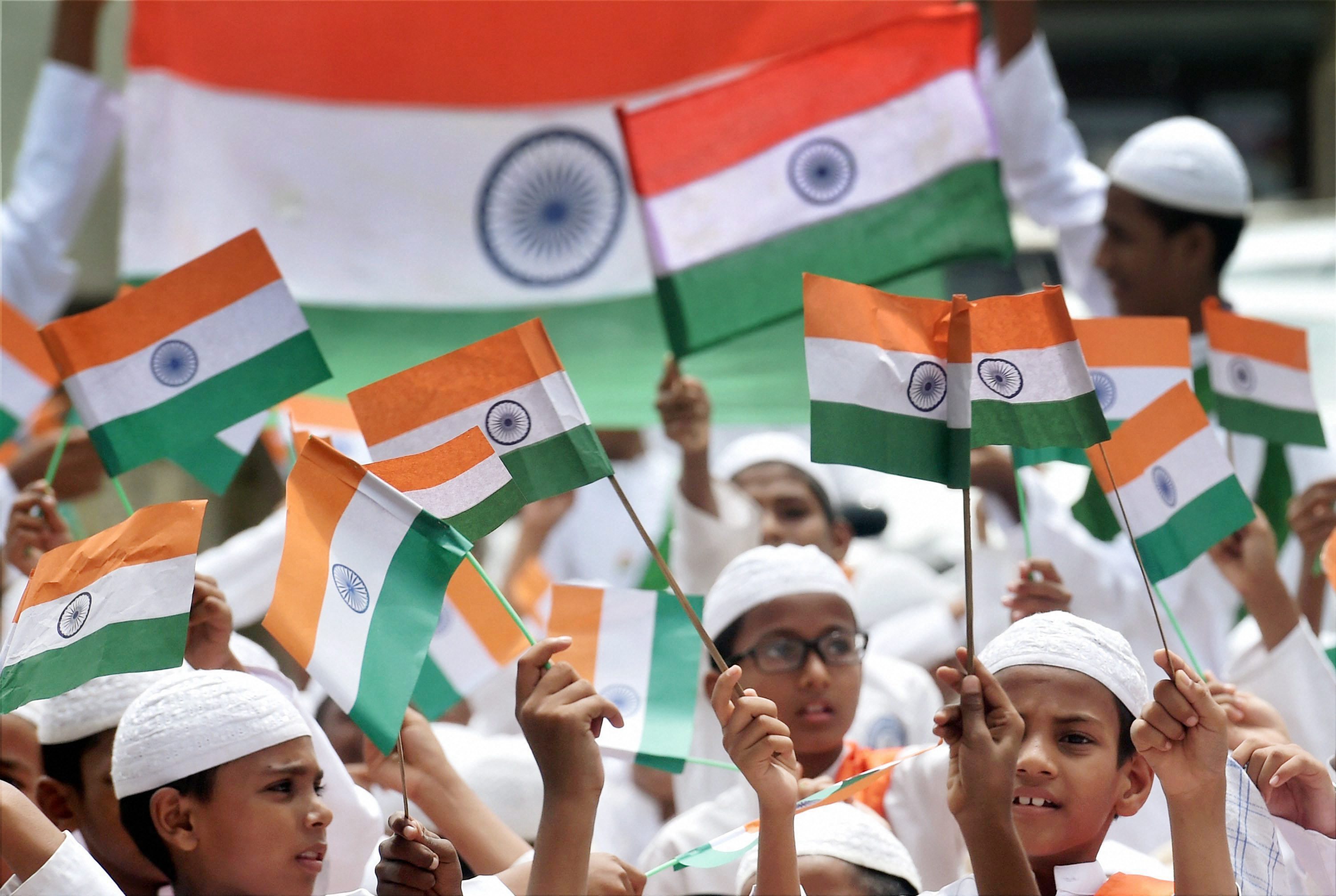 Mumbai: Students wave the Indian tricolor flag while celebrating the 71st Independence Day in Mumbai on Tuesday. PTI Photo by Santosh Hirlekar(PTI8_15_2017_000183B)