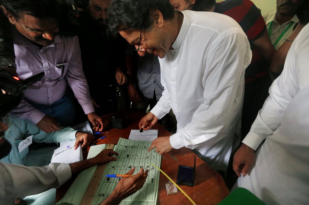 Islamabad: Pakistani politician Imran Khan, center, chief of Pakistan Tehreek-e-Insaf party, casts his vote at a polling station for the parliamentary elections in Islamabad, Pakistan, Wednesday, July 25, 2018. After an acrimonious campaign, polls opened in Pakistan on Wednesday to elect the country's third straight civilian government, a first for this majority Muslim nation that has been directly or indirectly ruled by its military for most of its 71-year history.AP/PTI(AP7_25_2018_000058B)