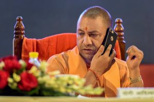 Lucknow: Uttar Pradesh Chief Minister Yogi Adityanath talks on a phone during an event, in Lucknow on Monday, Aug 6, 2018. (PTI Photo) (PTI8_6_2018_000127B)