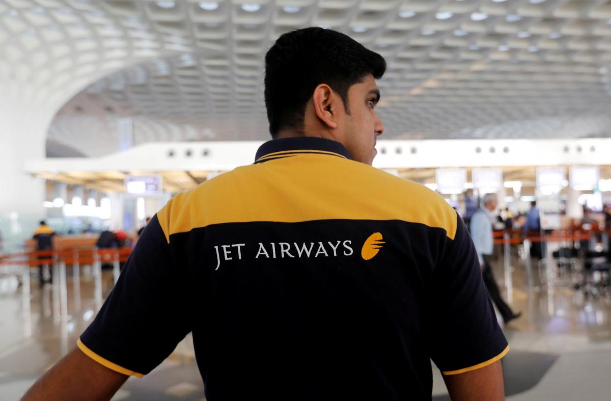 FILE PHOTO: A Jet Airways employee waits to guide passengers at a check-in counter at the Chhatrapati Shivaji International airport in Mumbai, India, February 14, 2018. REUTERS/Danish Siddiqui/File photo