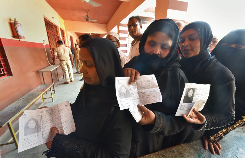 Rampur: Muslim women show their voter ID cards as they stand in a queue to cast their vote during the third phase of the 2019 Lok Sabha elections, at a polling station in Rampur, Tuesday, April 23, 2019. (PTI Photo/Kamal Kishore) (PTI4_23_2019_000125B)