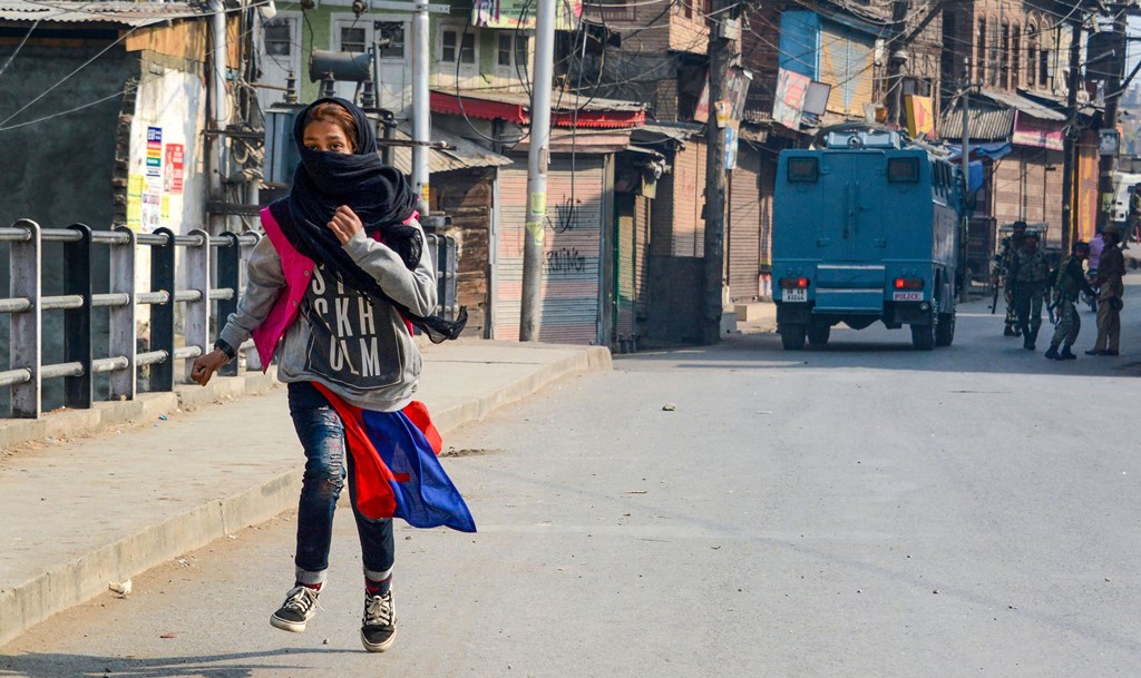 Srinagar:A girl runs for cover after throwing stones during a protest in Srinagar, Tuesday, Oct. 29, 2019. A delegation of 23 European Union MPs is on a visit to Jammu and Kashmir for a first-hand assessment of the situation in the Valley following the revocation of the state''s special status under Article 370. (PTI Photo) (PTI10_29_2019_000140A)