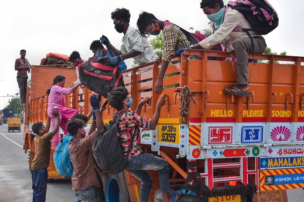 Vijayawada: Migrants climb onto a truck to reach to their native place in Bihar, during the ongoing COVID-19 nationwide lockdown, in Vijayawada, Tuesday, May 19, 2020. (PTI Photo)(PTI19-05-2020 000074B)