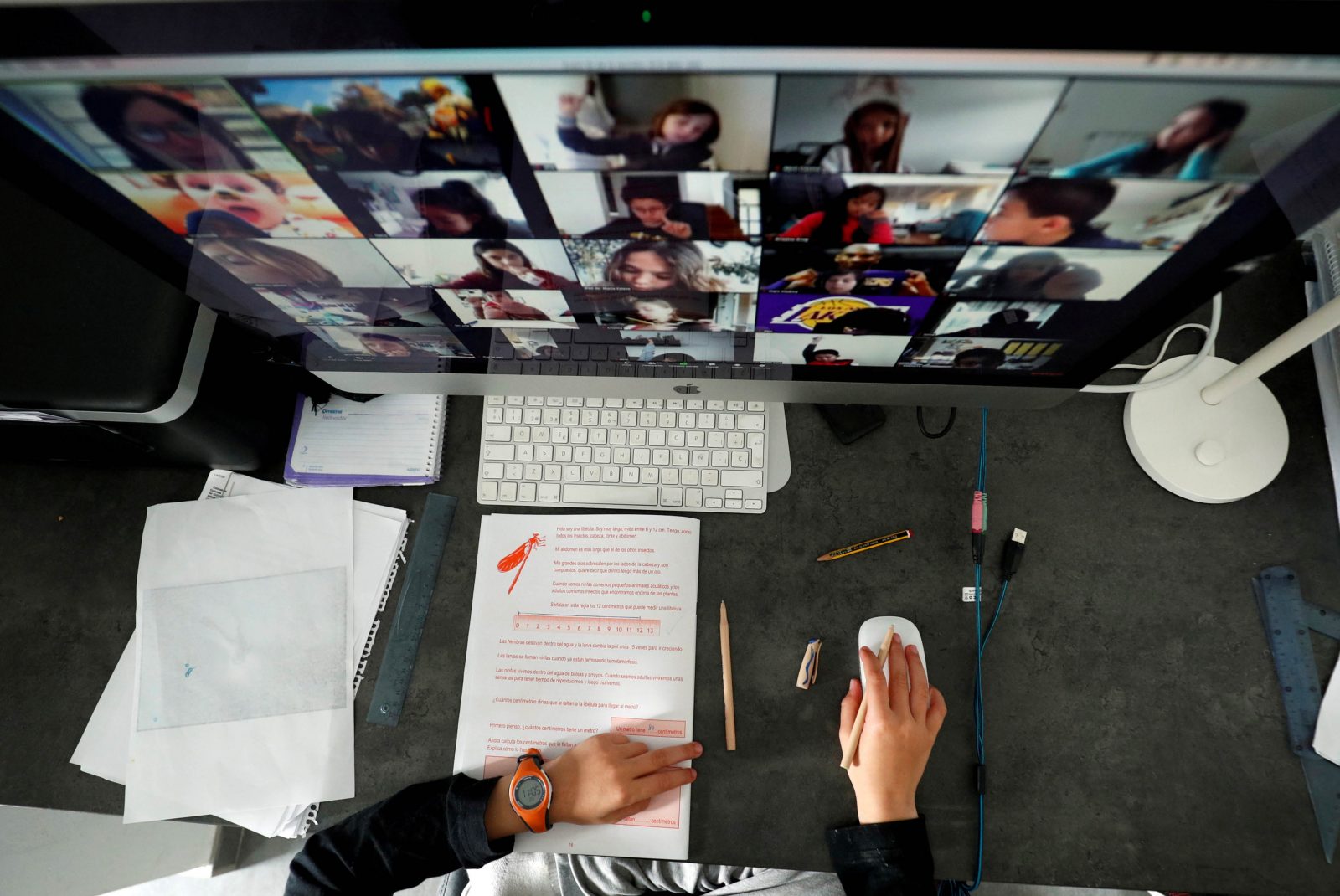 A student takes classes online with his companions using the Zoom app at home in El Masnou, north of Barcelona, Spain April 2, 2020. REUTERS/Albert Gea