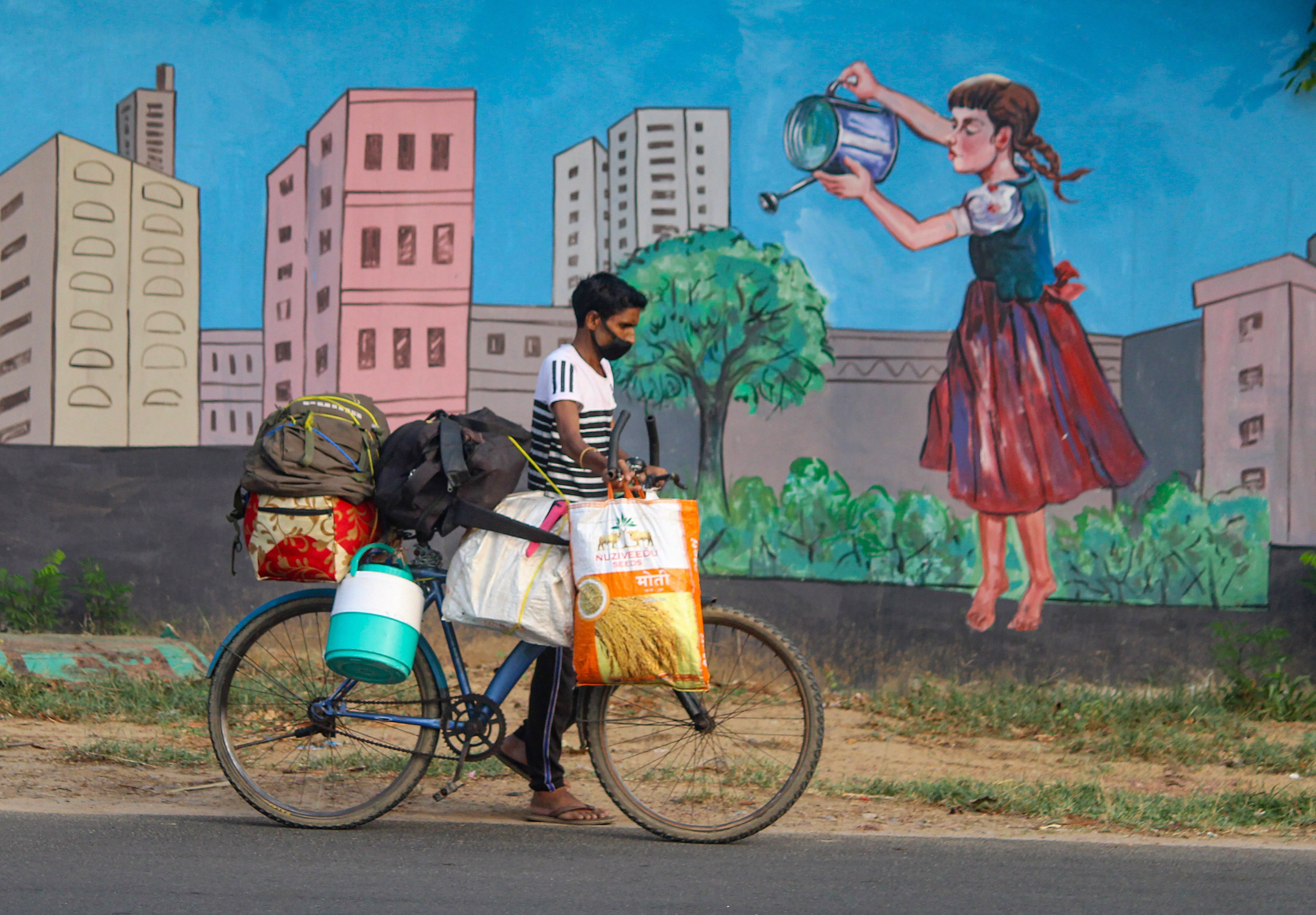 Gurugram: A migrant pulls his bicycle as he walks towards his native state, during the ongoing COVID-19 lockdown, near Sector 15 in Gurugram, Sunday, June 14, 2020. (PTI Photo)(PTI14-06-2020_000223B)