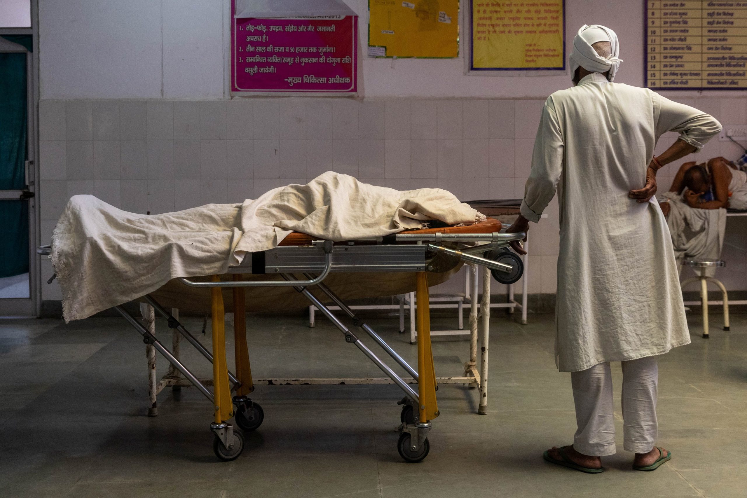 A man stands next to the body of his wife, who died due to breathing difficulties, inside an emergency ward of a government-run hospital, amidst the coronavirus disease (COVID-19) pandemic, in Bijnor, Uttar Pradesh, India, May 11, 2021. REUTERS/Danish Siddiqui