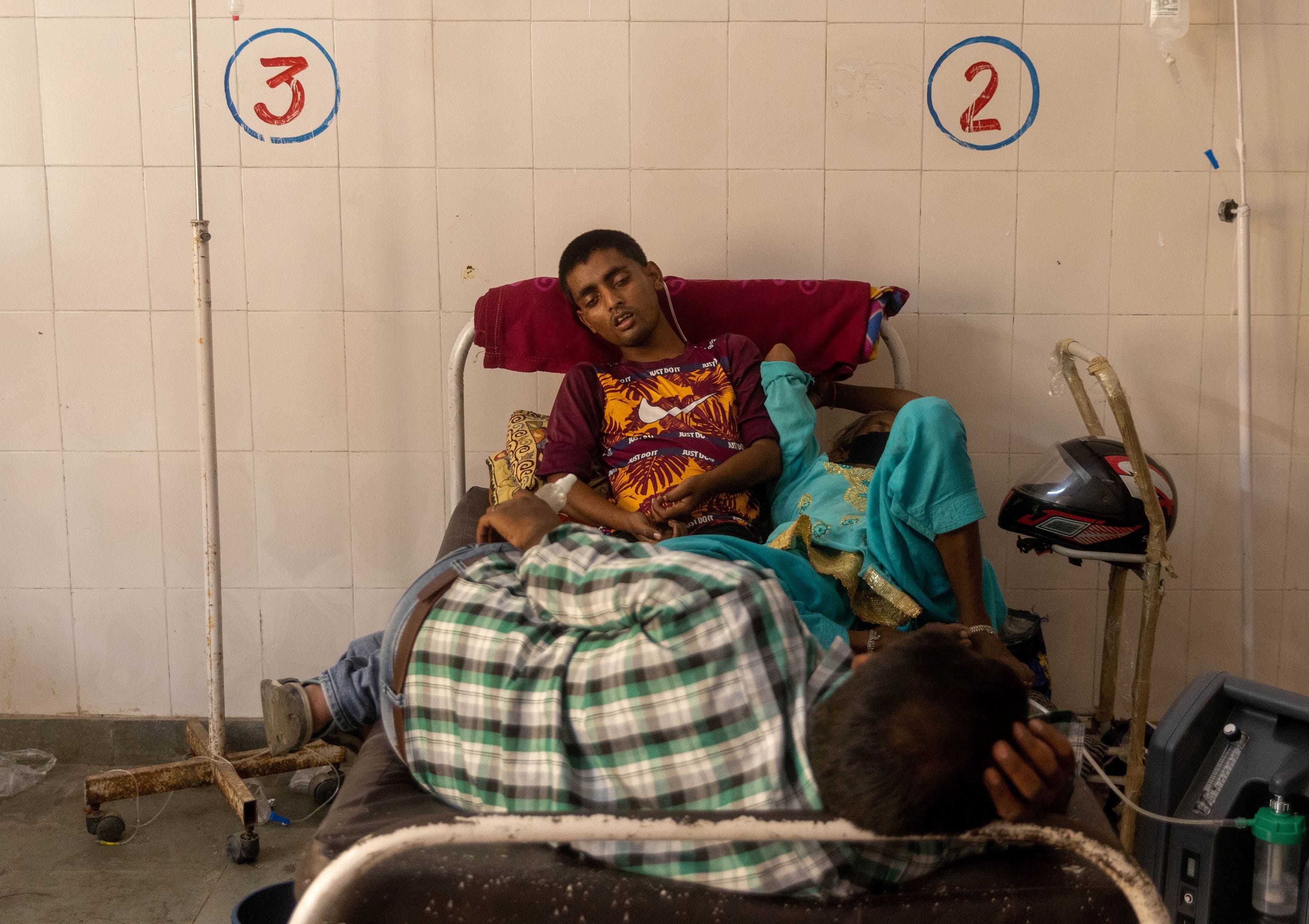 उत्तर प्रदेश के बिजनौर शहर स्थित सरकारी अस्पताल के एक बिस्तर पर लेटे मरीज. (फोटो: रॉयटर्स)
