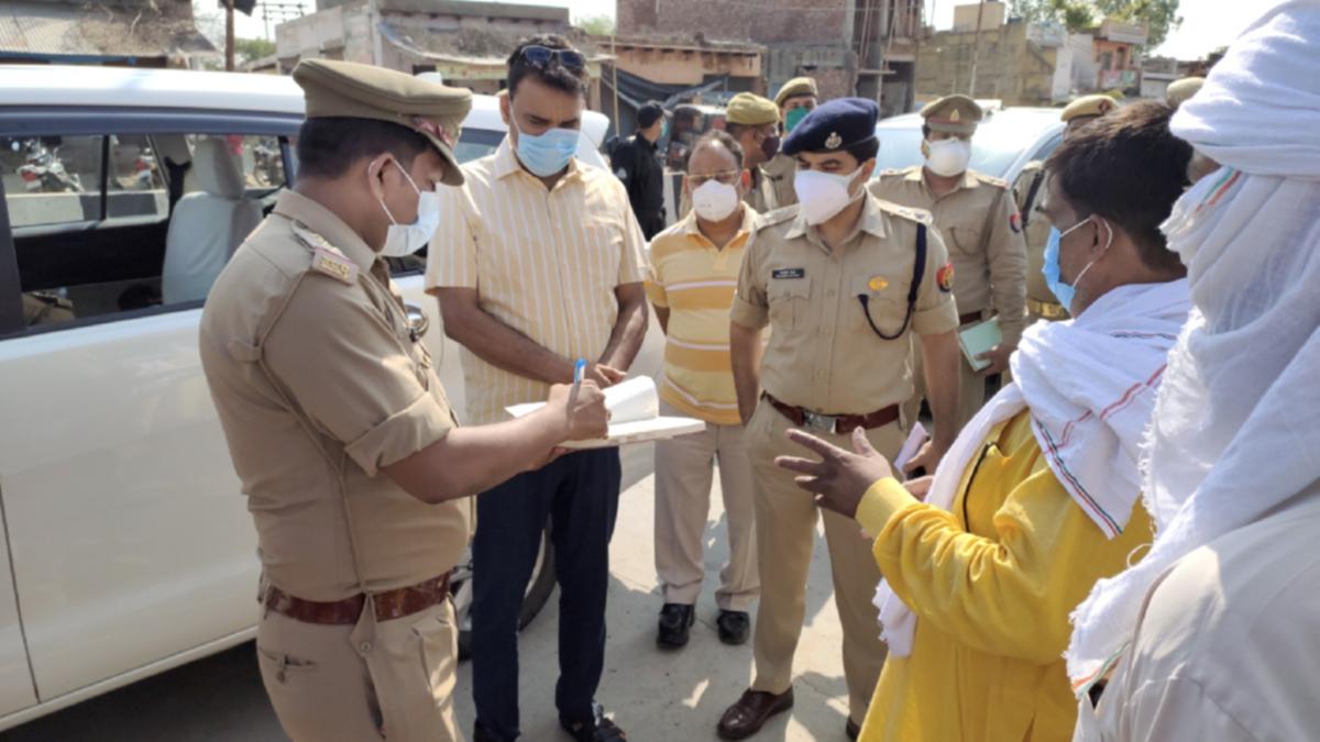 Police officers investigate after people died due to allegedly consuming spurious liquor sold by a licensed vendor in Aligarh district. 2021 (Photo credit: PTI)