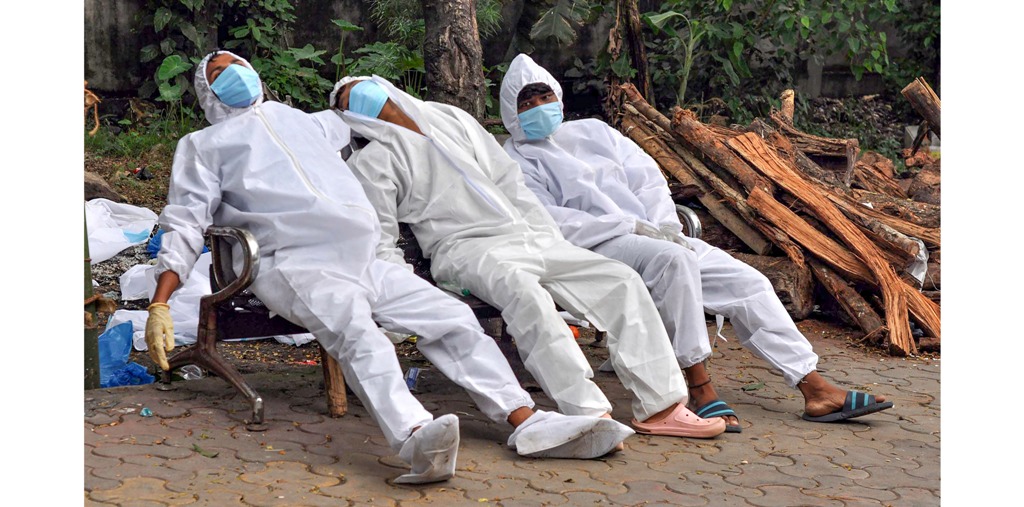 असम की राजधानी गुवाहाटी के अंतिम संस्कार स्थल पर आराम करते स्वास्थ्यकर्मी. (फोटो: पीटीआई)