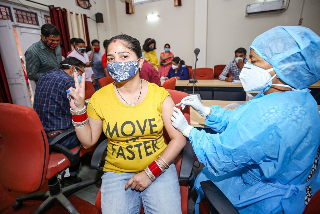 जम्मू के कंपनी बाग स्थित एक टीकाकरण केंद्र में एक महिला ने कोविड-19 टीके का पहला डोज लिया. (फोटो: पीटीआई)