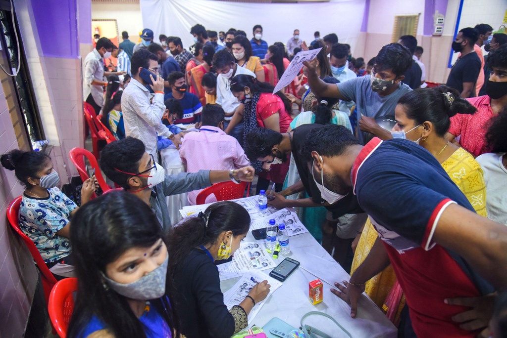 मुंबई के विले पार्ले पूर्व स्थित एक टीकाकरण केंद्र में कोविड-19 टीका लगवाने के लिए जुटी भीड़. (फोटो: पीटीआई)