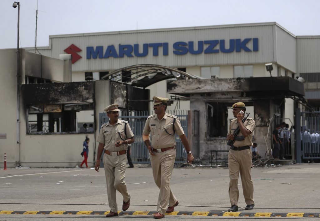 Police officials walk outside the Maruti Suzuki's plant in Manesar, located in the northern Indian state of Haryana, July 19, 2012. Police were searching on Thursday for 3,000 people they want to detain after one person was killed and scores injured in a riot at the Maruti Suzuki factory in Manesar. Hundreds of police have secured the plant, arresting 88 people after property was smashed and parts of the factory set on fire during Wednesday's violence, police said. REUTERS/Ahmad Masood (INDIA - Tags: BUSINESS CIVIL UNREST MILITARY TRANSPORT)