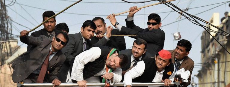 Lucknow : Security persons pushing away elctric cables above Uttar Pradesh Chief Minister and Samajwadi Party President Akhilesh Yadav and Congress Vice President Rahul Gandhi as they duck to avoid them during a road show in Lucknow on Sunday. PTI Photo by Nand Kumar (PTI1_29_2017_000224B)