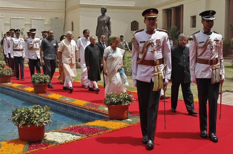 Indian President Pranab Mukherjee (C) arrives along with Prime Minister Narendra Modi (on his L) and Lok Sabha speaker Sumitra Mahajan (wearing sari), to address the joint session of the parliament in New Delhi June 9, 2014. Containing food inflation will be the top priority of Prime Minister Narendra Modi's new government, Mukherjee said in a parliamentary address on Monday, with an emphasis on improving supplies and farm pricing. REUTERS/Stringer (INDIA - Tags: POLITICS) - RTR3STTC