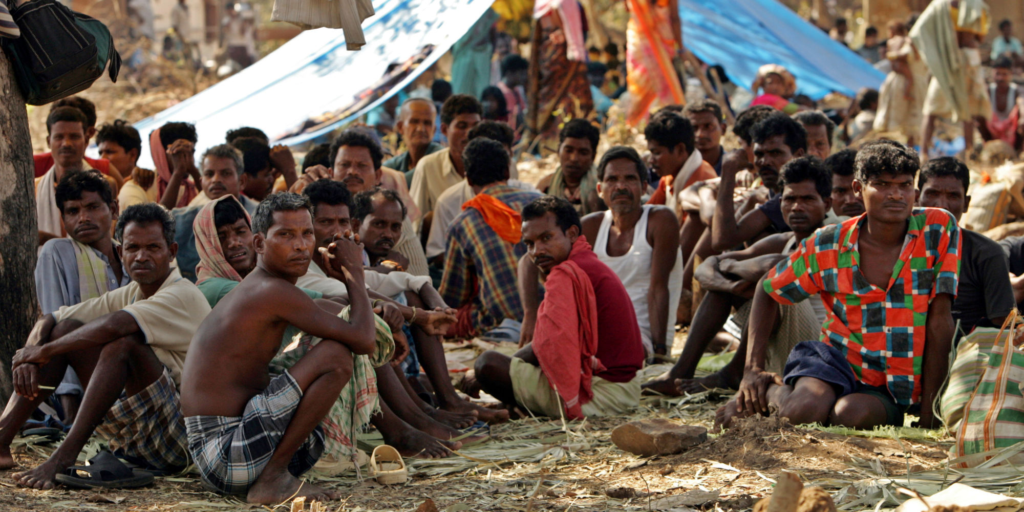 Indian tribal people sit at a relief camp in Dharbaguda, in the central state of Chhattisgarh, March 8, 2006. Violence in Chhattisgarh, one of India's poorest states, has mounted since the state government set up and started funding an anti-Maoist movement. Picture taken March 8, 2006.   REUTERS/Kamal Kishore