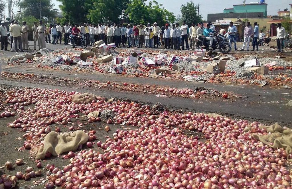 Nashik: Farmers throwing onions and other vegetables on the road during their state-wide strike over various demands in Nasik, Maharashtra on Thursady. PTI Photo (PTI6_1_2017_000201B)