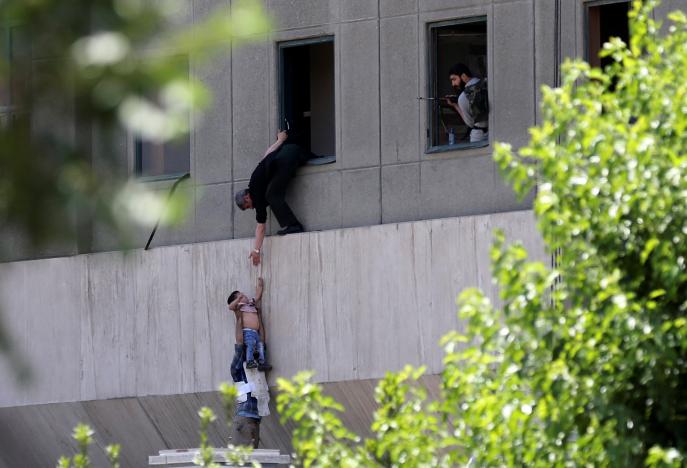 A boy is evacuated during an attack on the Iranian parliament in central Tehran, Iran, June 7, 2017. Omid Vahabzadeh/TIMA via REUTERS
