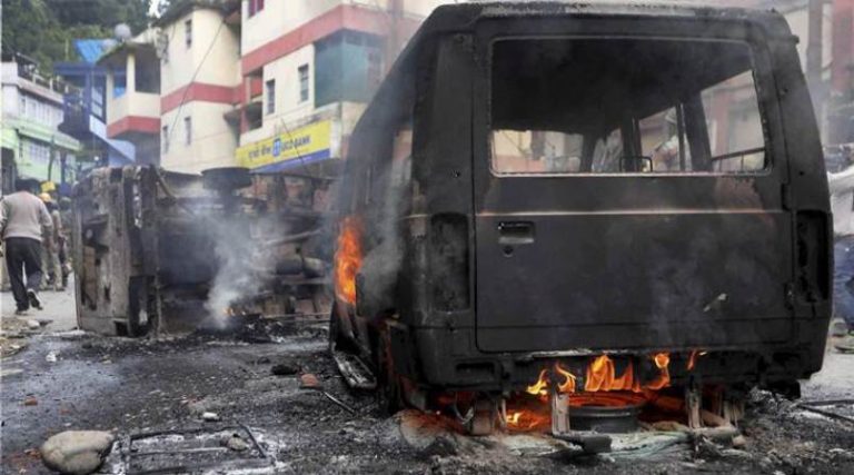 Darjeeling: Army Personnel patrol near burning vehicles after clashes with supporters of GJM in Darjeeling on Saturday. PTI Photo(PTI6_17_2017_000185A)