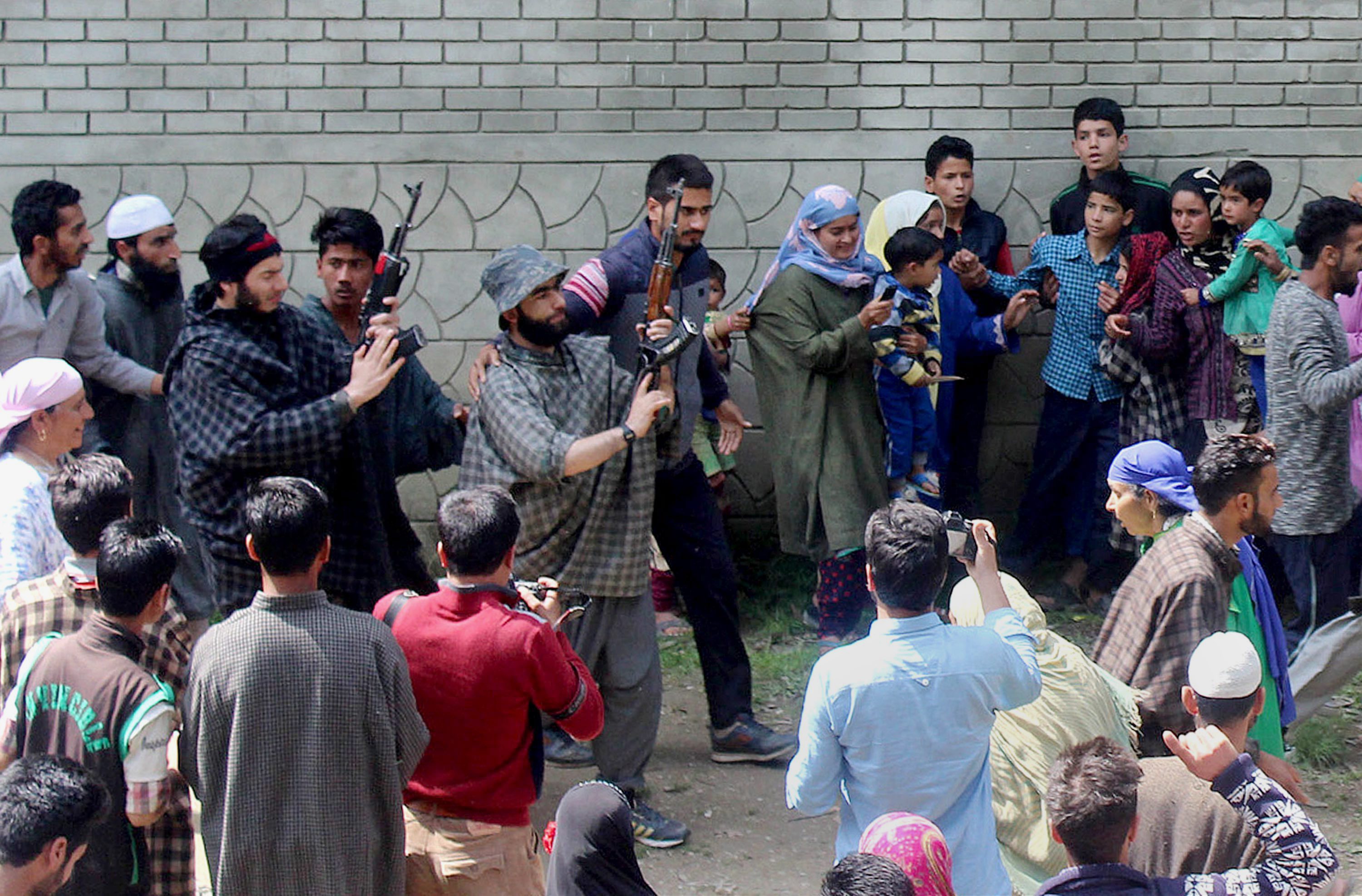 Kulgam: Suspected militants brandish their guns and shout slogans at the funeral of a slain colleague, killed in a shootout with the police, at Qoimoh in Kulgam district of south Kashmir on Sunday. PTI Photo (PTI5_7_2017_000188B)