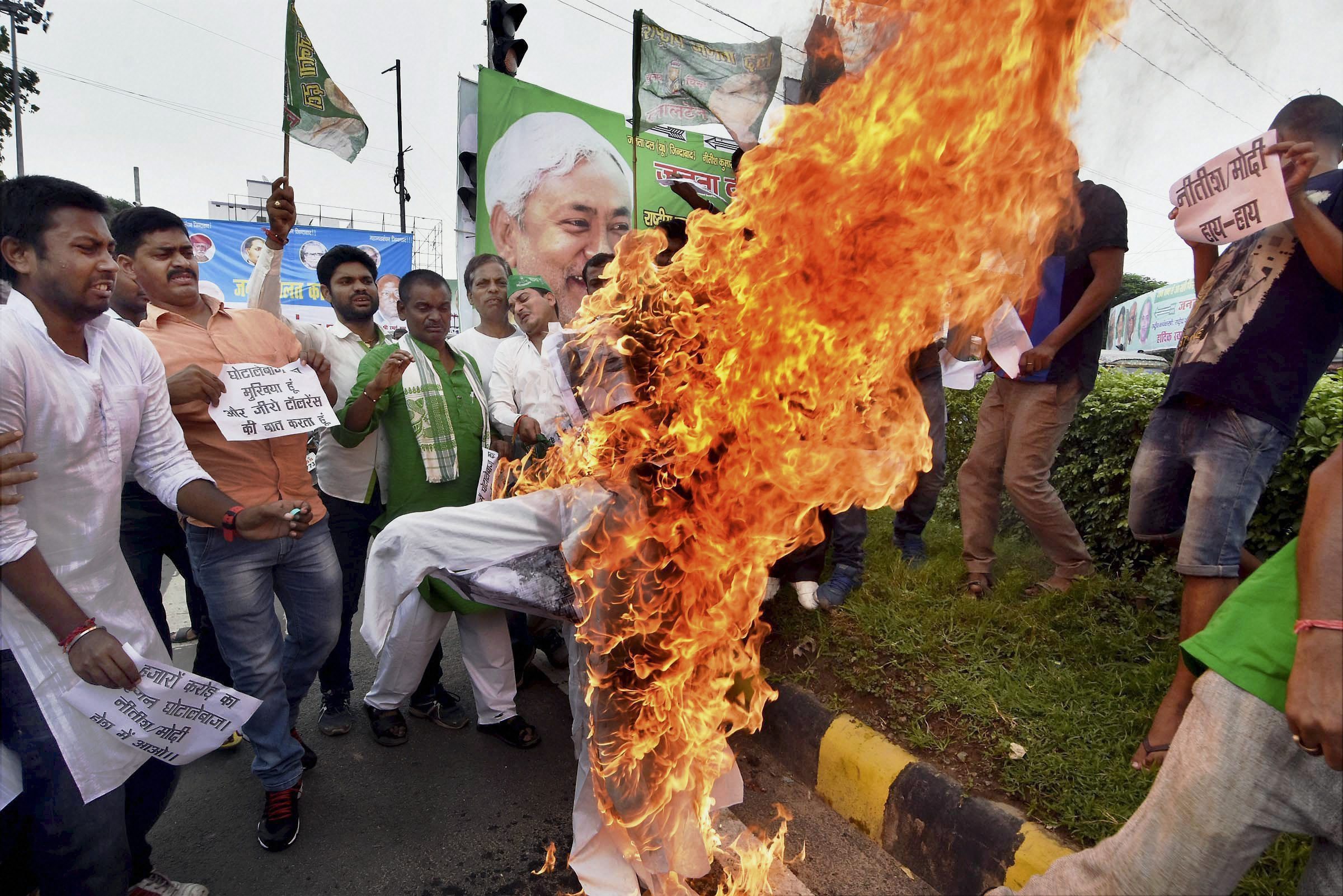 Patna: RJD activists burning an effigy of Bihar Chief Minister Nitish Kumar during a protest against Bhagalpur Srijan scam in Patna on Friday. PTI Photo(PTI8_18_2017_000090A)