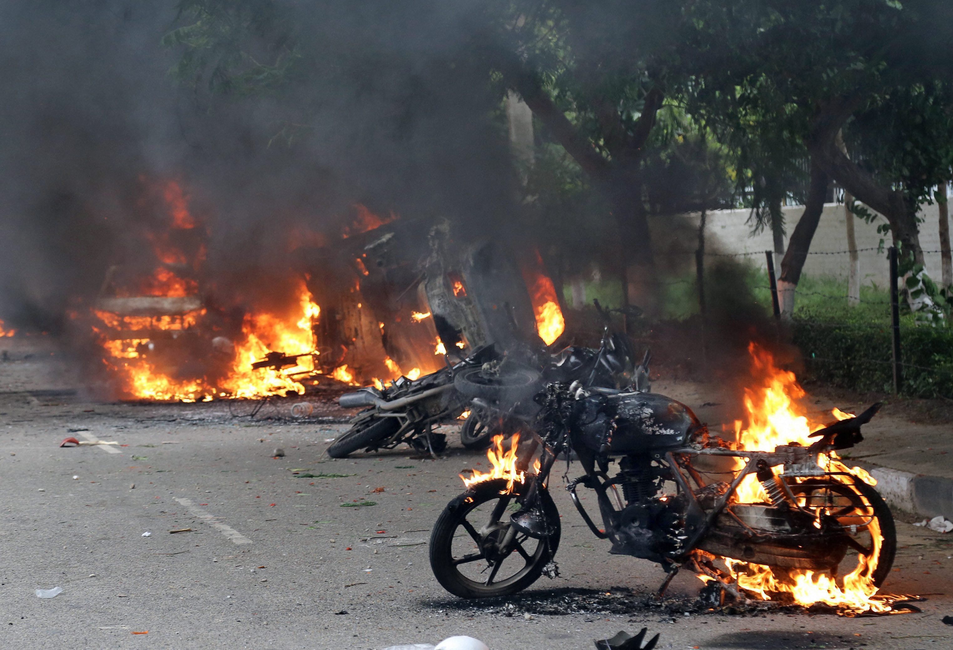 Panchkula: Vehicles burn in violence following Dera Sacha Sauda chief Gurmeet Ram Rahims conviction in Panchkula on Friday. PTI Photo (PTI8_25_2017_000183B)