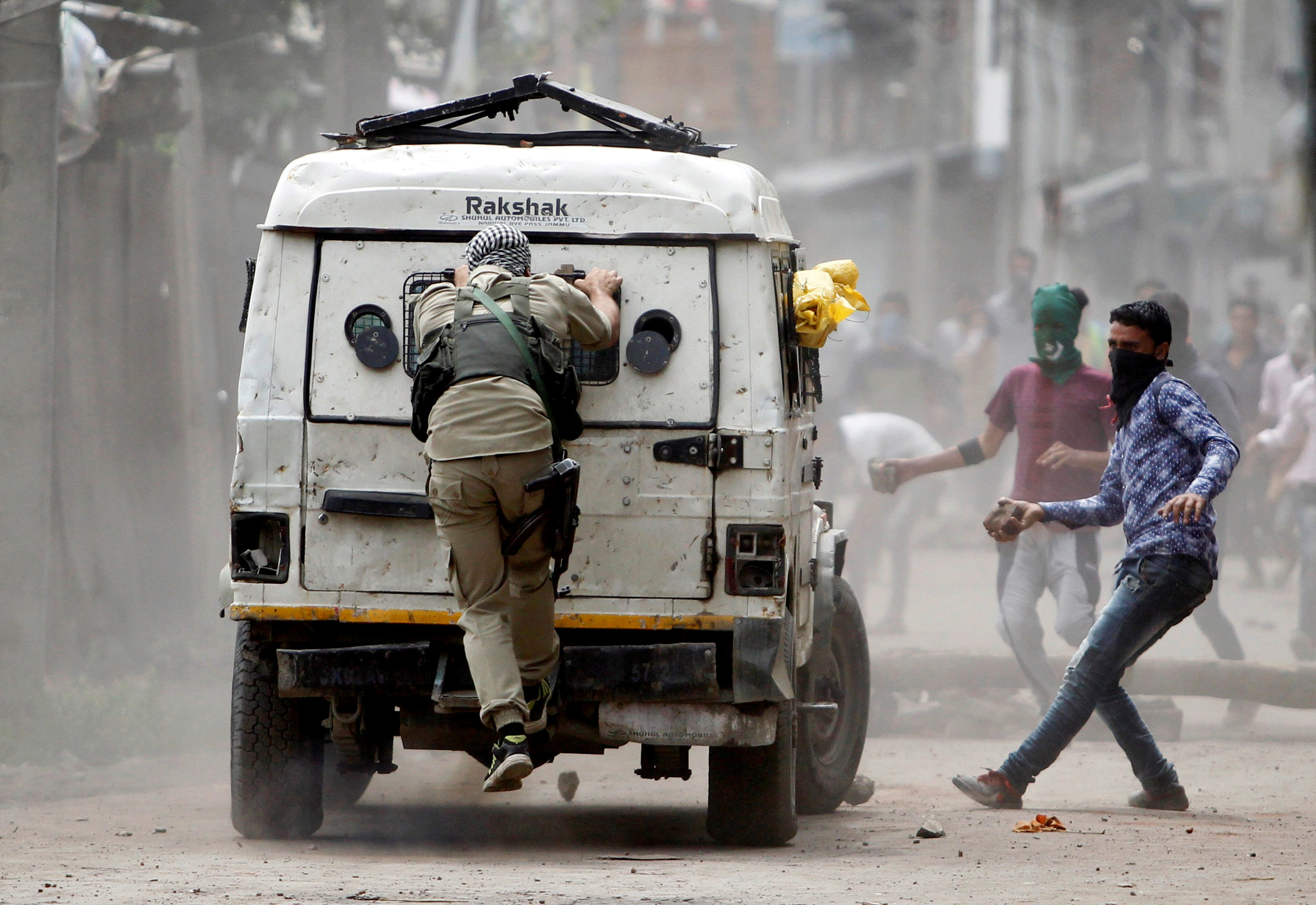 Demonstrators try to hurl stones at an Indian police vehicle during a protest in Srinagar against the recent killings in Kashmir, August 30, 2016. To match Insight INDIA-KASHMIR/ REUTERS/Danish Ismail/File Photo