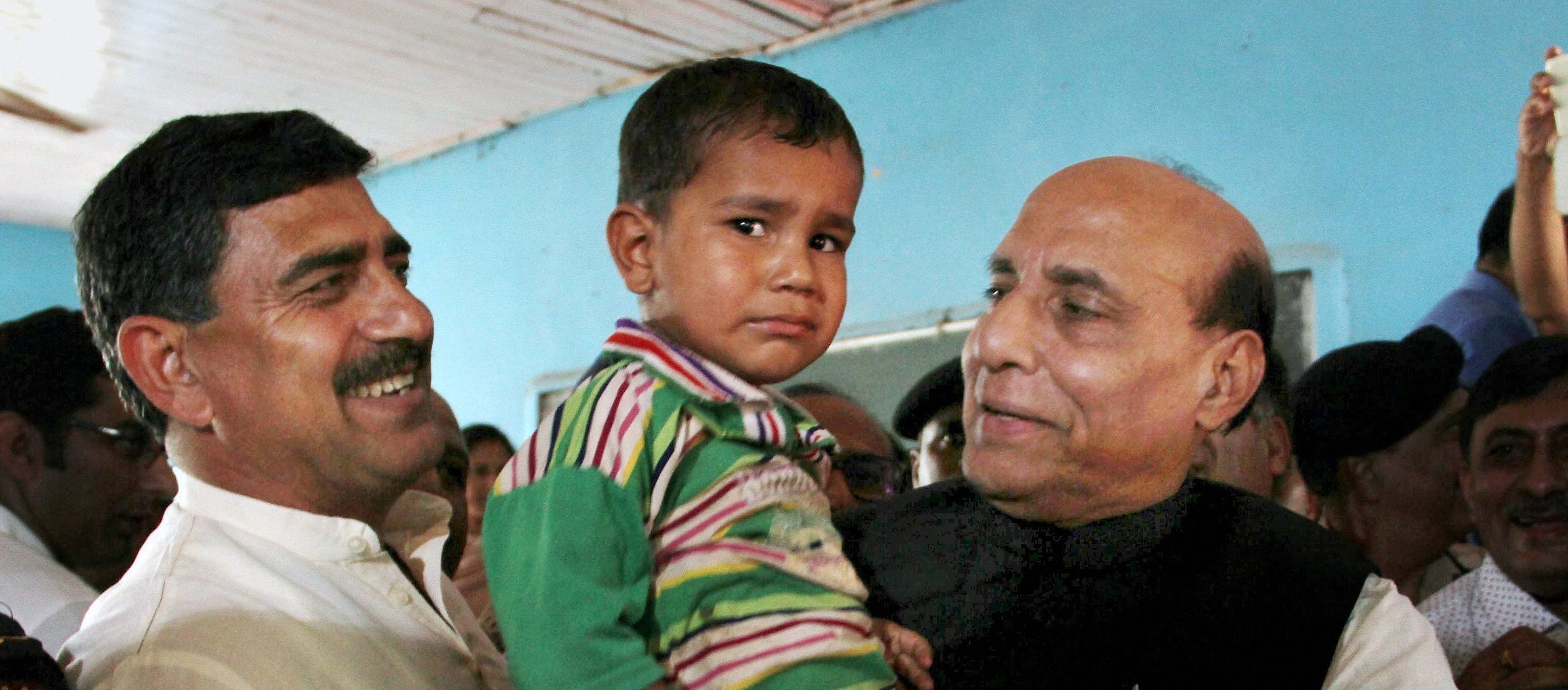 Rajouri: Union Home Minister Rajnath Singh interacts with a child during his visit to a border migrants camp in Nowshera sector of Rajouri district on Monday. PTI Photo (PTI9_11_2017_000119B)