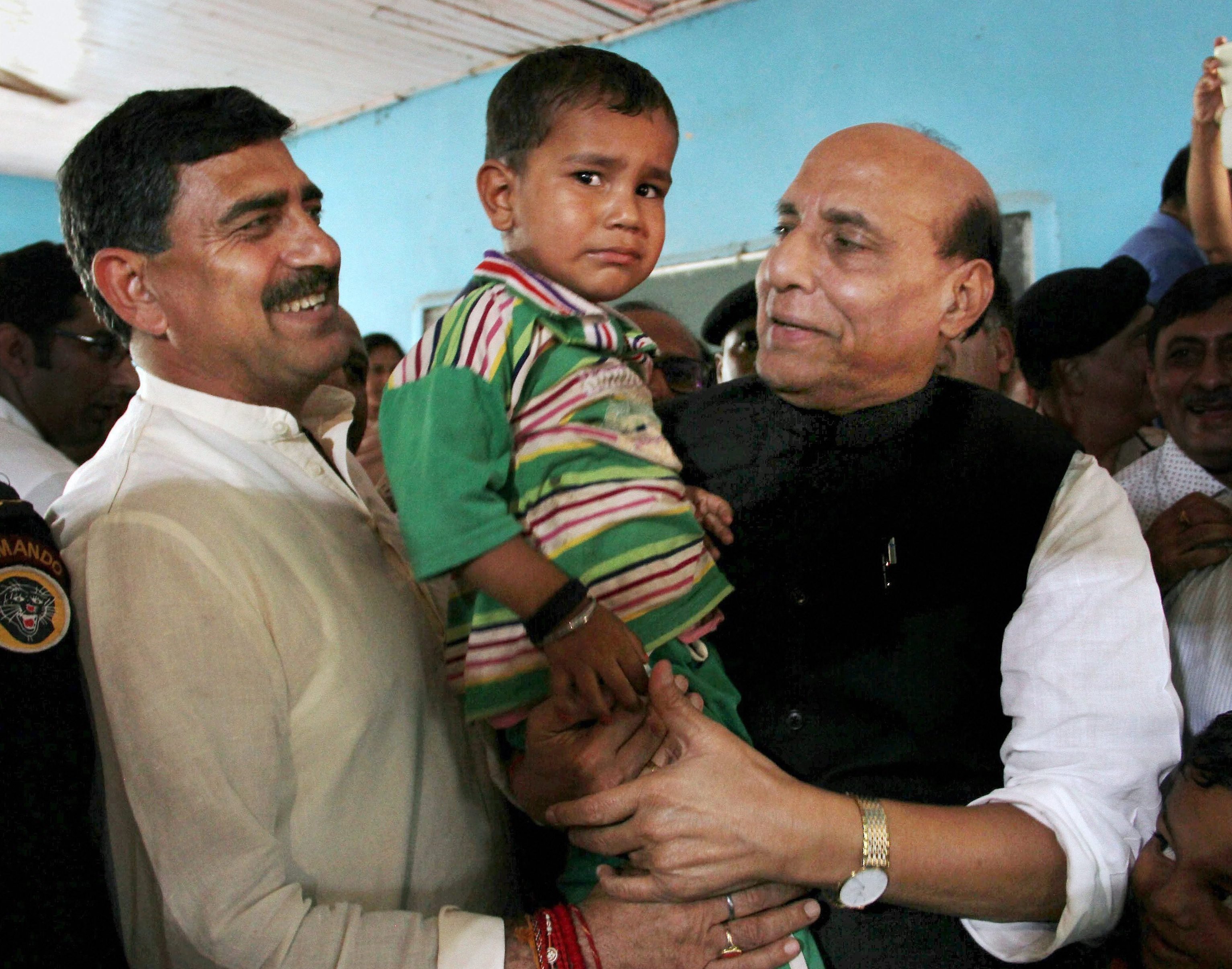 Rajouri: Union Home Minister Rajnath Singh interacts with a child during his visit to a border migrants camp in Nowshera sector of Rajouri district on Monday. PTI Photo (PTI9_11_2017_000119B)