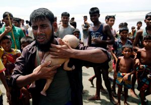 Ahmed, a Rohingya refugee man cries as he holds his 40-day-old son, who died as a boat capsized in the shore of Shah Porir Dwip while crossing Bangladesh-Myanmar border, in Teknaf, Bangladesh. Reuters