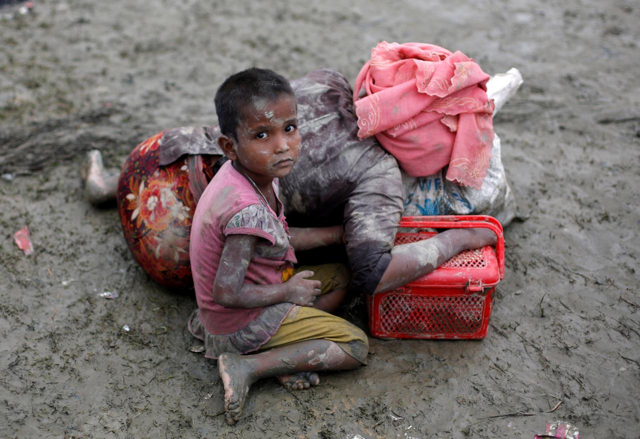 A Rohingya refugee girl sits next to her mother who rests after crossing the Bangladesh-Myanmar border, in Teknaf, Bangladesh, September 6, 2017. REUTERS/Danish Siddiqui