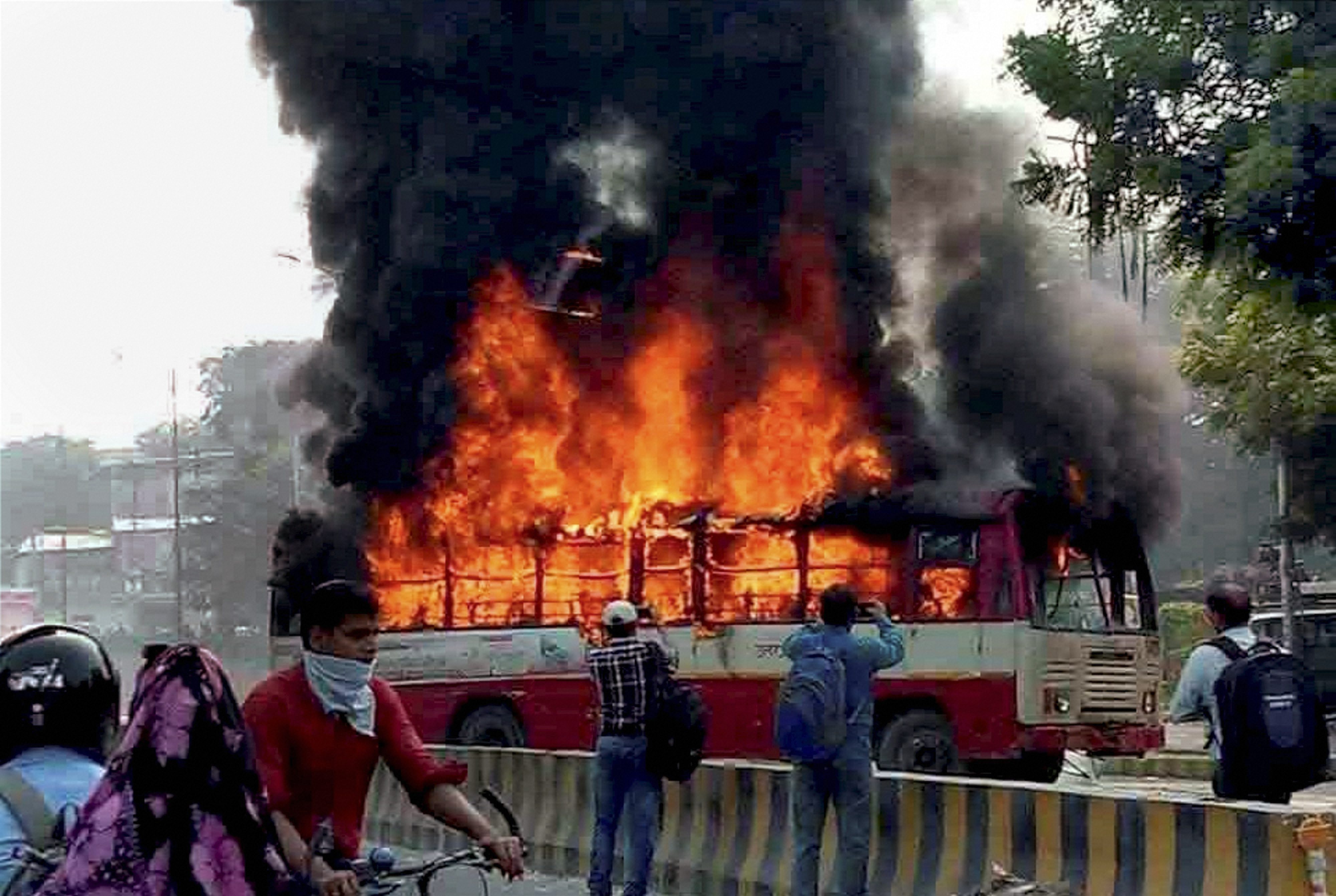 Allahabad: Angry relatives and people set ablaze a UP Roadways bus during a protest against the murder of BSP leader Rajesh Yadav, in Allahabad on Tuesday. Yadav was shot dead at the Allahabad University's Tara Chandra Hostel on Monday night. PTI Photo (PTI10_3_2017_000087B)