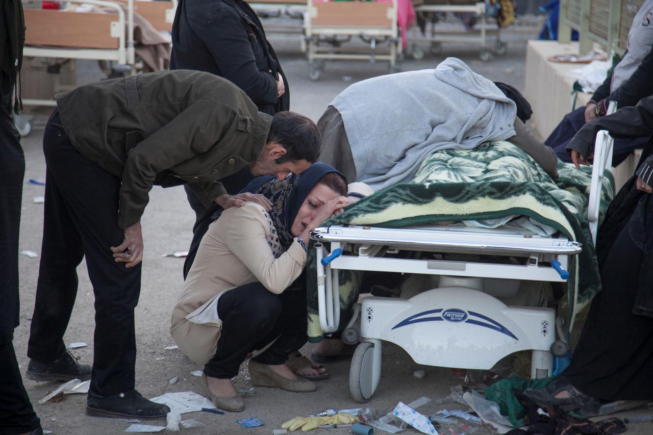 A woman reacts next to a dead body following an earthquake in Sarpol-e Zahab county in Kermanshah, Iran.  REUTERS/Tasnim News Agency