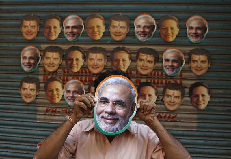 A vendor wears a mask of Hindu nationalist Narendra Modi, prime ministerial candidate for main opposition Bharatiya Janata Party (BJP) and Gujarat's chief minister, to attract customers at his stall selling masks of Indian political leaders ahead of general election in the southern Indian city of Chennai April 3, 2014. India, the world's largest democracy, will hold its general election in nine stages staggered between April 7 and May 12. REUTERS/Babu (INDIA - Tags: ELECTIONS POLITICS TPX IMAGES OF THE DAY) - RTR3JSS0
