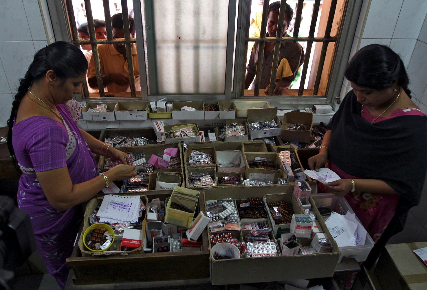 Pharmacists dispense free medication, provided by the government, to patients at Rajiv Gandhi Government General Hospital (RGGGH) in Chennai July 12, 2012. Chennai is the capital of Tamil Nadu, one of two Indian states offering free medicine for all. The state provides a glimpse of the hurdles India faces as it embarks on a programme to extend free drug coverage nationwide. Picture taken July 12, 2012. To match Analysis INDIA-DRUGS/ REUTERS/Babu (INDIA - Tags: SOCIETY DRUGS HEALTH) - RTR357H6