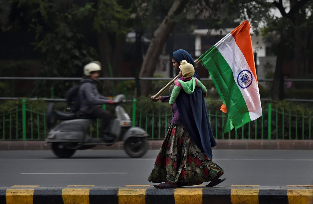 New Delhi: A woman sells the Indian national flag on a roadside ahead of Republic Day, in New Delhi on Wednesday. (PTI Photo by Ravi Choudhary)(PTI1_24_2018_000293B)