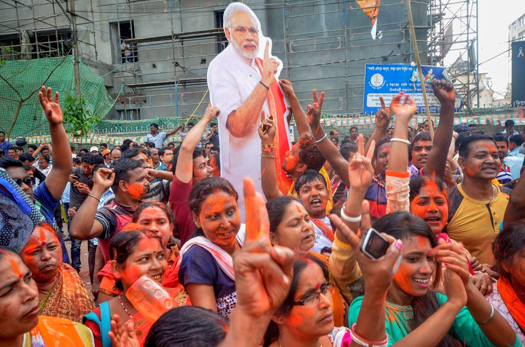 Agartala: BJP supporters hold up a placard of Prime Minister Narendra Modi after party's victory in Tripura Assembly elections results in Agartala on Saturday. BJP's win marks an end to 25 years of CPI-M government rule in the state. PTI Photo. PTI Photo (PTI3_3_2018_000097B)