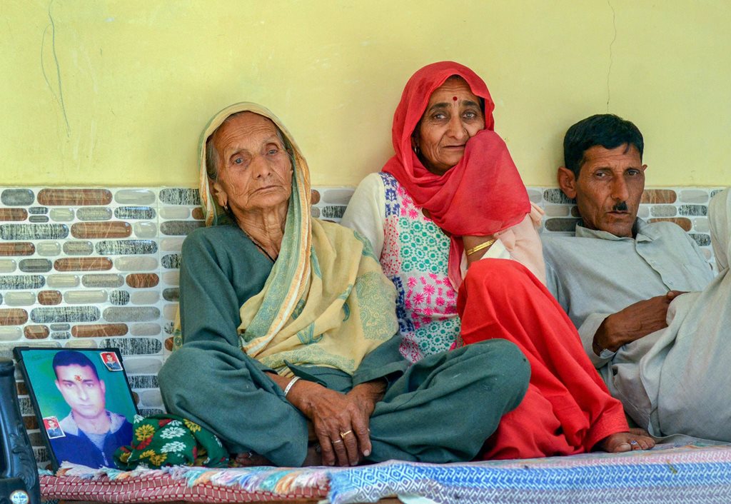 Dharamshala: Family members grieve by a portrait of Aman, one of the 39 Indian workers feared killed in Iraq, at Passu village near Dharamshala on Tuesday. External Affairs Minister Sushma Swaraj in a statement made at Rajya Sabha today, stated that the 39 bodies exhumed from a mount in Badoosh in Iraq have been identified as those of abducted Indians and will be brought back to India on a special plane. PTI Photo(PTI3_20_2018_000157B)