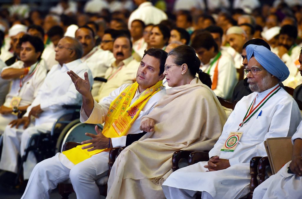 New Delhi: Chairperson CPP Sonia Gandhi and President Rahul Gandhi talk as former Prime Minister Manmohan Singh looks on, during the 84th Plenary Session of Indian National Congress (INC) at the Indira Gandhi Stadium in New Delhi on Saturday. PTI Photo by Manvender Vashist (PTI3_17_2018_000112B)