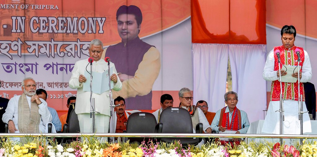 Agartala: Tripura BJP President Biplab Kumar Deb being sworn-in as the 10th chief minister of the state by Governor Tathagata Roy during a ceremony in Agartala on Friday. Prime Minister Narendra Modi is also seen on the stage. PTI Photo (PTI3 9 2018 000102B) *** Local Caption ***