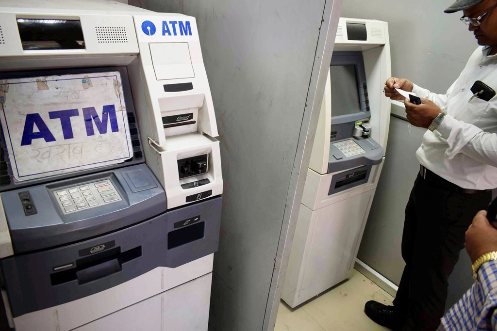 Allahabad: A man stand next to an out-of-service Automated Teller Machine (ATM) in Allahabad on Wednesday. PTI Photo (PTI4_18_2018_000120B)