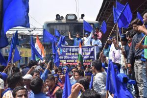 Patna: Bhim Army Sena members stop a train during 'Bharat Bandh' call given by Dalit organisations against the alleged 'dilution' of the Scheduled Castes and Scheduled Tribes act, in Patna on Monday. PTI Photo(PTI4_2_2018_000043B)