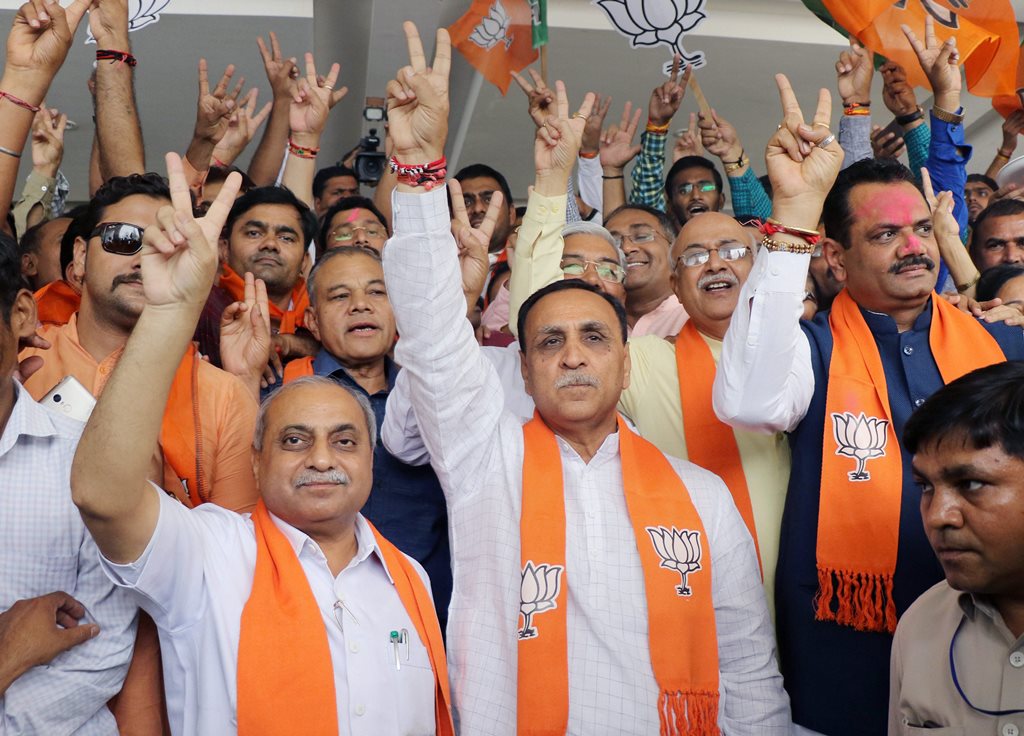 Gandhinagar: Gujarat Chief Minister Vijay Rupani, deputy Chief Minister Nitin Patel, State President Jitu Vaghani and other BJP leaders show victor sign as they celebrate the party's performance in Karnataka Assembly elections, at the BJP office “Kamalam” at Gandhinagar on Tuesday. PTI Photo (PTI5_15_2018_000073B)