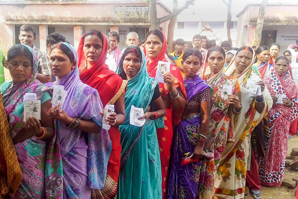 Gomia: Voters show their Election Commission cards as they queue to cast their vote at a polling station, during Gomia constituency Assembly by-election, at Gomia, on Monday, 28 May 2018. (PTI Photo) (PTI5_28_2018_000037B)