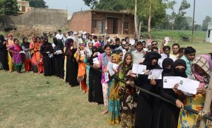 Bijnor: Burqa-clad women, along with other voters, show their voter identity cards as they wait to cast thier votes for Noorpur Assembly bypolls, in Bijnor, on Monday, May28, 2018. (PTI Photo) (PTI5_28_2018_000075B)