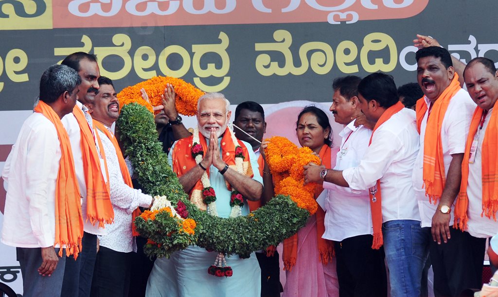 Udupi: Prime Minister Narendra Modi being garlanded by BJP workers at an election campaign rally ahead of Karnataka polls, in Udupi on Tuesday. PTI Photo 