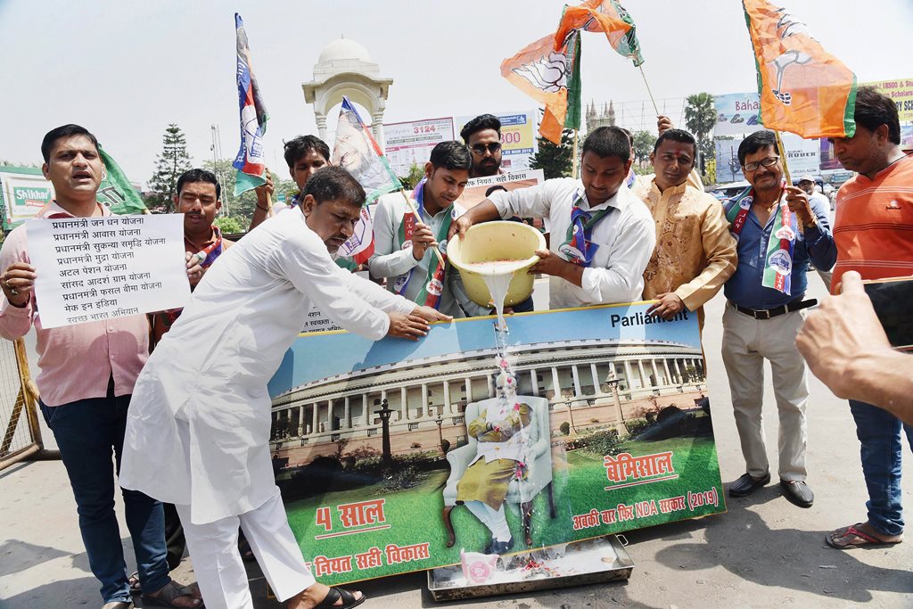 Patna: NDA supporter milk bath a photo of PM Narendra Modi as they celebrate the 4th anniversary of the Narendra Modi-led BJP government, in Patna on Saturday