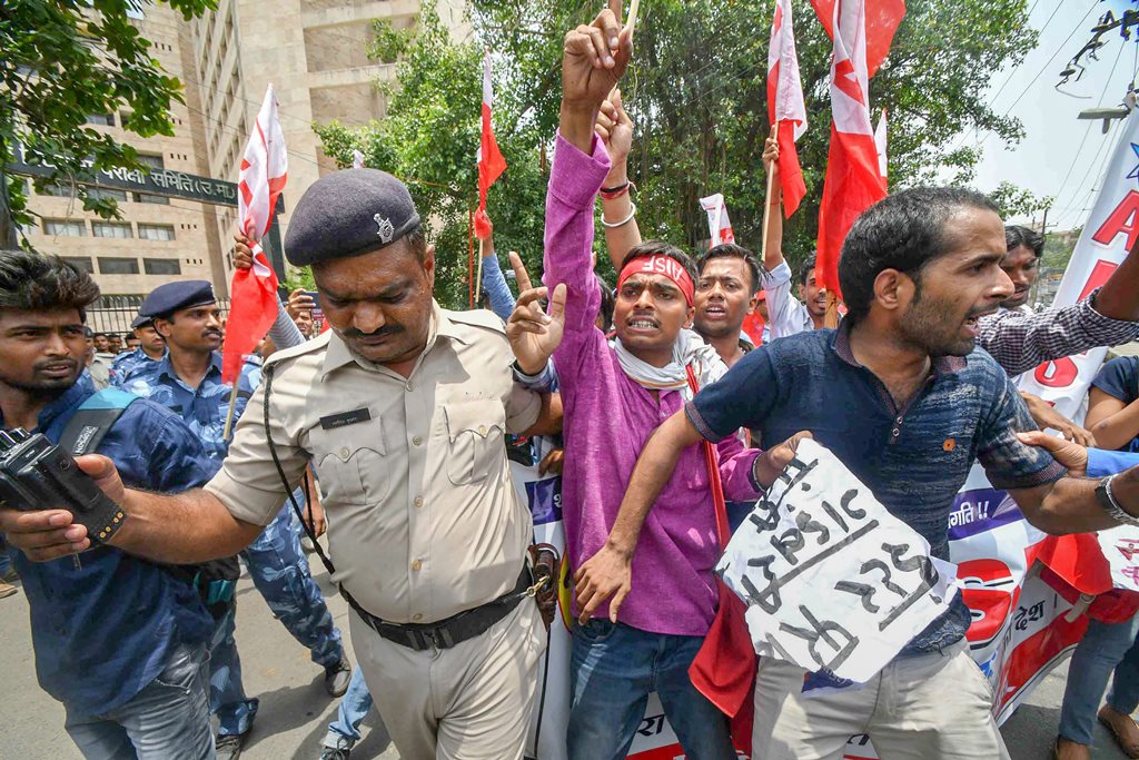 Patna: Police personnel detain All India Students Federation activists during a protest against the low pass percentage in the Intermediate exams, in Patna on Wednesday, June 13, 2018. (PTI Photo) (PTI6_13_2018_000047B)