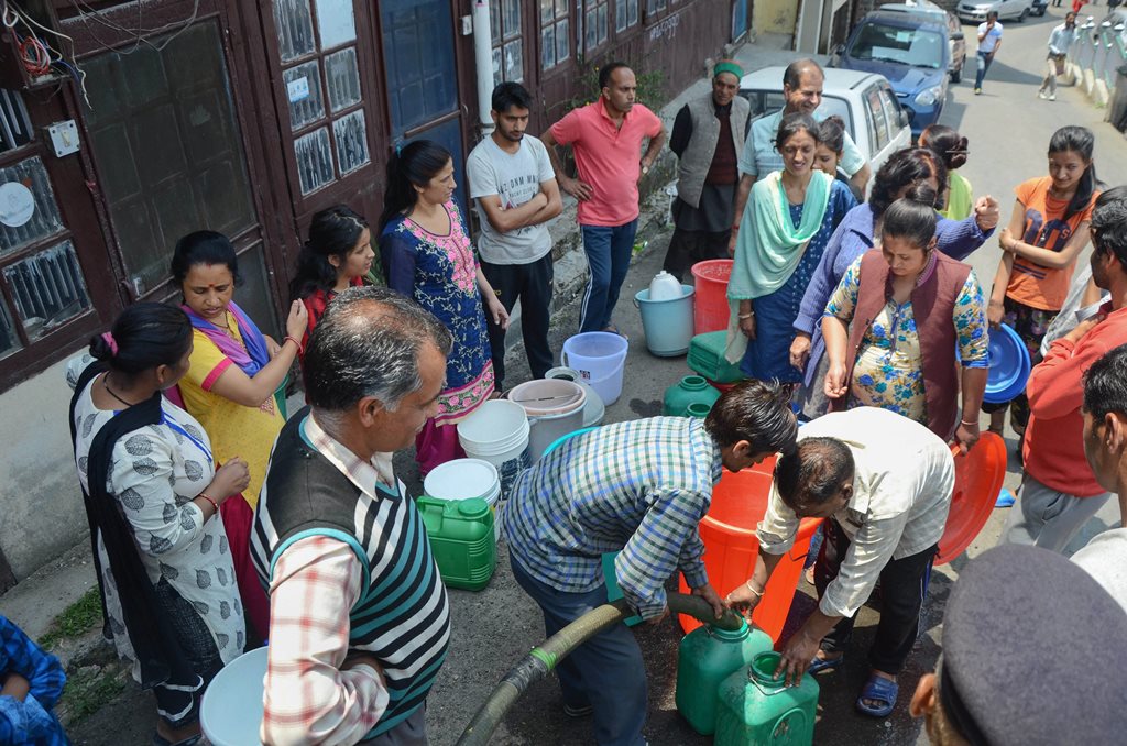 Shimla: People wait to collect water from a tanker, as the city faces acute shortage of drinking water, in Shimla on Wednesday, May 30, 2018. (PTI Photo) (PTI5_30_2018_000115B)