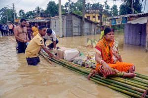 Kailashahar: A woman on a bamboo raft carrying food and water through a flooded street, in Kailashahar on Friday, June 15, 2018. (PTI Photo) (PTI6_16_2018_000101B)